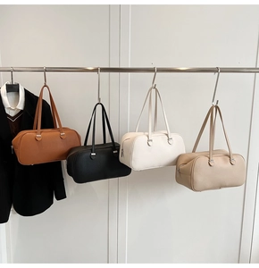 Detail view of four Boston style shoulder bags in brown, black, white, and beige leather