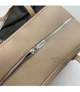 Macro detail of silver metal zipper and beige lychee pattern leather on shoulder bag