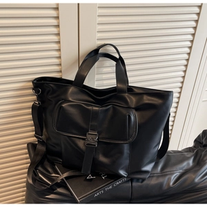 Détail du grand sac cabas noir en cuir avec boucle fonctionnelle et texture brillante