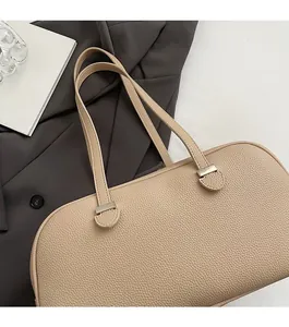 Close-up of litchi grain texture and silver hardware on a solid color Boston bag
