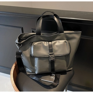Détail d'un sac cabas utilitaire gris-vert avec boucle noire et texture cuir mat