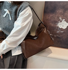 Detail of vintage brown leather tote bag with elegant silver metallic twist lock closure