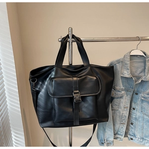 Détail d'un grand sac cabas en cuir PU noir avec boucle tactique et poche avant