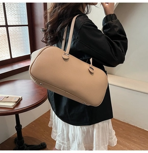 Detail view of beige lychee texture leather shoulder bag with silver metal protective feet