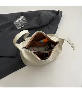 Detail view showing large interior capacity with a zip pocket in a cream shoulder bag
