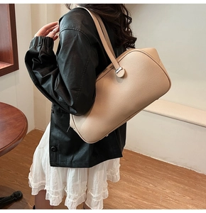 Detail shot of apricot pebble leather texture and silver buckle on shoulder bag