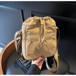 Dettaglio della borsa a secchiello kaki con coulisse in tessuto di nylon pieghettato