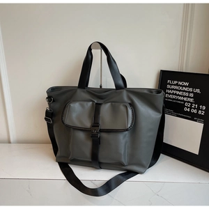 Détail du sac cabas gris avec bandoulière en nylon noir réglable et boucle de fermeture