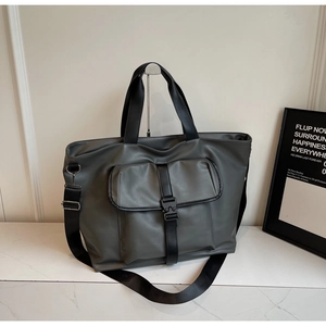 Détail d'un sac cabas gris avec poche avant à boucle et bandoulière en nylon réglable