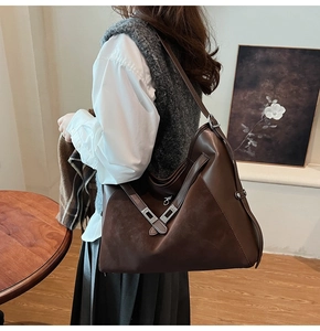 Brown vintage hobo tote bag shown on model with smooth leather and suede stitching detail