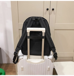 Detail showing back luggage strap and ergonomic padded straps on black backpack