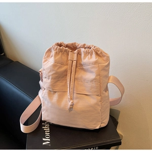 Dettaglio borsa a secchiello in nylon rosa con chiusura a coulisse e cuciture esterne