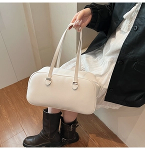 Detailed view of white litchi grain leather texture on a modern rectangular underarm bag
