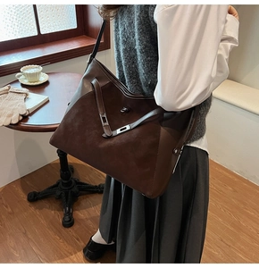 Detail view of dark brown tote bag showing textured suede and smooth leather splicing