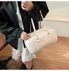 Detail of cream rectangle underarm bag with lychee grain texture and silver zipper