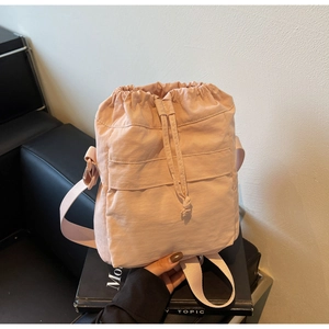 Dettaglio di una borsa a secchiello in nylon rosa pallido con chiusura a coulisse