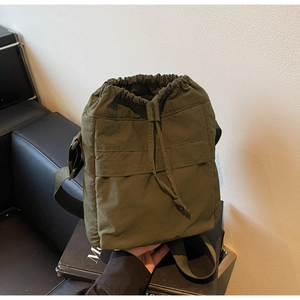 Dettaglio della borsa a secchiello in nylon verde oliva con texture plissettata