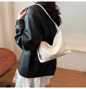 Détail du sac hobo blanc crème en similicuir avec pendentif cœur et fini brillant