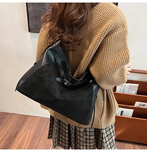 Detail of vintage black leather hobo bag showing crossbody strap and buckle on shoulder