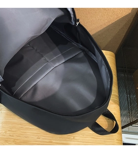 Internal view of a spacious black backpack showing the grey lining and storage pocket