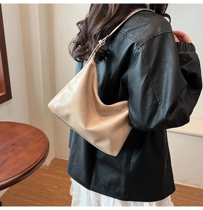 Détail du sac sous l'aisselle beige montrant la texture plissée et la bandoulière fine