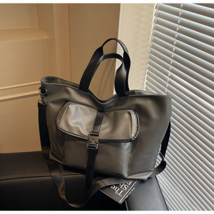 Détail du cabas en cuir mat gris foncé avec poche fonctionnelle à boucle métallique