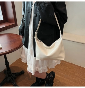Texture détaillée du sac hobo blanc cassé avec une finition en similicuir souple