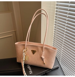 Détail du sac cabas rose en similicuir avec logo triangle et breloque de raquette
