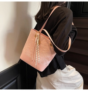 Pink PU leather tote bag with embossed bear pattern and striped rope charm detail
