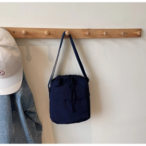Dettaglio della borsa a secchiello in nylon blu navy con texture impermeabile