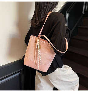Detail of pink underarm bucket bag with star embossing and gold ring strap attachments
