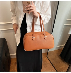 Detailed view of caramel pebble leather tote bag with sturdy shoulder straps and silver buckles