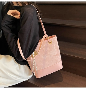 Detail view of pink semi-transparent tote bag with 3D bear patterns and tassel charm