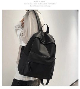 Detail view of the black minimalist waterproof backpack showing side pockets and wide straps