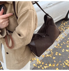 Close-up of brown leather and suede patchwork shoulder bag with elegant metal buckle