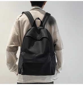 Rear view of model wearing a minimalist black waterproof backpack with matte finish