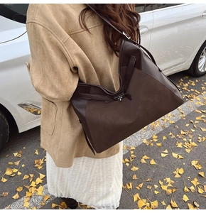 Side view of dark brown tote bag with metal butterfly buckle and leather patchwork