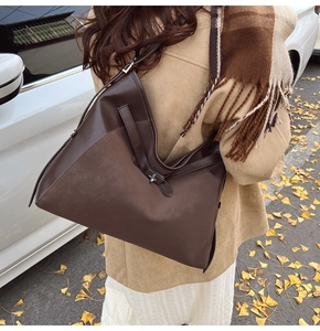 Deep brown matte leather tote bag styled with an autumn coat in a street setting