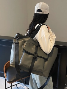 Grand sac cabas en cuir vert olive avec large bandoulière porté par un mannequin