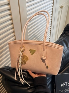 Sac à épaule rose en similicuir avec logo triangulaire et pendentif tressé