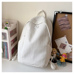 Close-up of the white minimalist backpack showing its unique woven texture and zipper detail