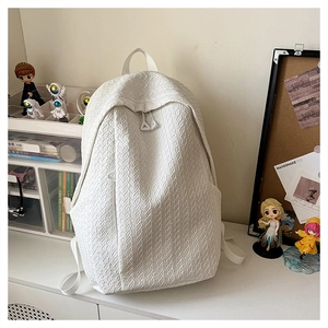 Close-up of white woven texture casual backpack with dual zippers on a desk