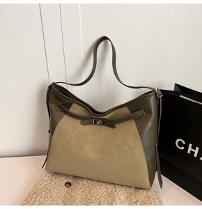 Detail of vintage tote bag with olive leather patchwork and metal twist lock closure