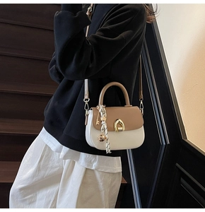 Detail of saddle bag featuring gold horseshoe buckle and decorative geometric silk scarf