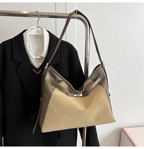 Detail of olive green and beige suede hobo bag with silver metal swivel lock