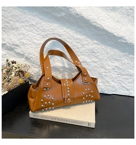Detail van vintage bruine draagtas met gepolijste zilveren noppen en decoratieve gespband