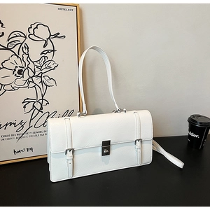 Detail of white rectangular bag with cracked texture, silver buckle, and flap closure