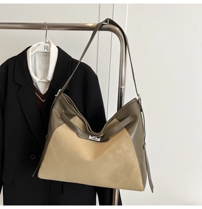 Detail of a large color-block tote bag with metallic turn-lock and leather textures