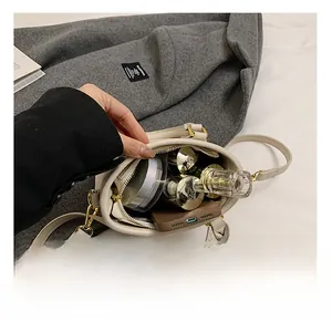 Interior view of the cream leather bucket bag showing capacity for phone and cosmetics