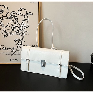 Detail of a white minimalist shoulder bag with silver hardware and rotating buckle lock